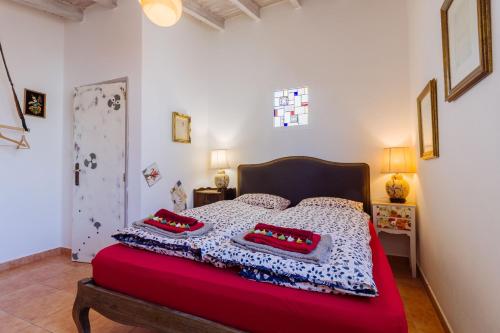 a bedroom with a bed with red pillows on it at Casa tempo e amor in Vila do Bispo