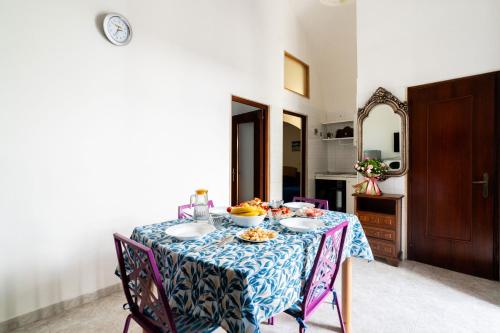 a dining room table with a blue and white table cloth at Tina House & Parking by BarbarHouse in Bari