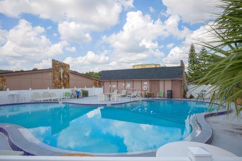 a large pool with blue water in front of a building at Liberty Inn and Suites Kissimmee near Disney World in Kissimmee
