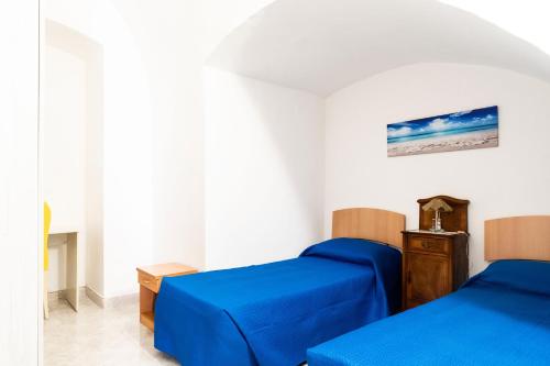 two beds in a room with blue sheets at Tina House & Parking by BarbarHouse in Bari