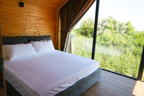 a bed in a room with a large window at Amazonas Pirates 4 in Gornji Štoj