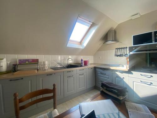 une cuisine avec des armoires blanches et une fenêtre dans l'établissement Les embruns - Mer - dog friendly, à Ault