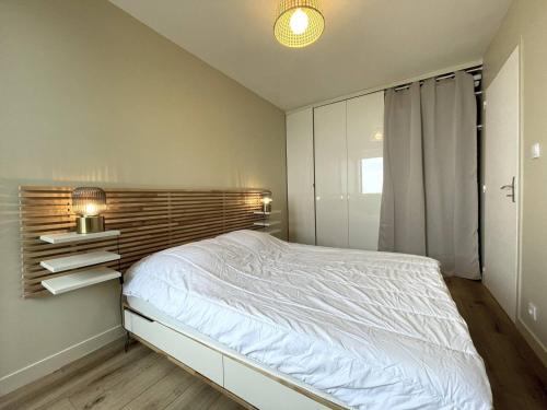 une chambre avec un lit blanc et une fenêtre dans l'établissement Appartement 3* plage de Trestraou, WiFi, parking, animaux ok - FR-1-368-435, à Perros-Guirec