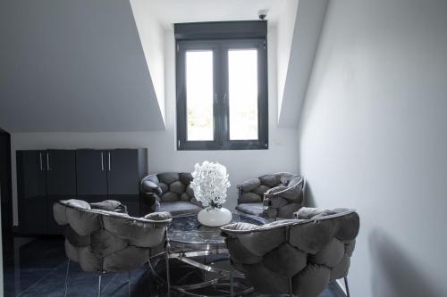 a living room with a table and two chairs and a window at Domaine de Bracheux Beauvais Chambre avec petit déjeuner inclus in Beauvais