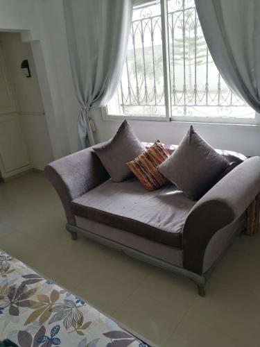 a couch sitting in a room with a window at Villa standing avec piscine privée sans vis à vis et WiFi à Djerba in Fafou