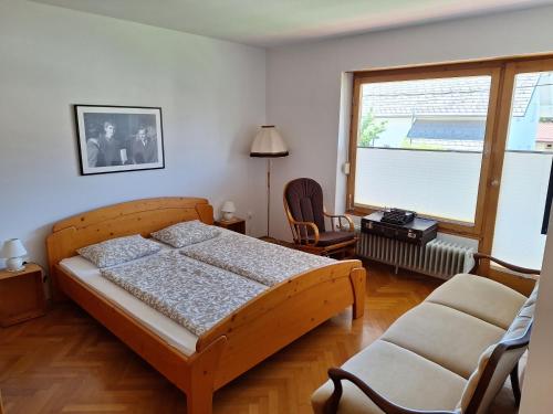 ein Schlafzimmer mit einem Bett und einem Stuhl und einem Fenster in der Unterkunft Vintage Apartment Bled in Bled