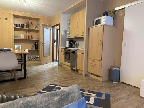 a living room with a kitchen with a refrigerator and a table at Moderne und komfortable Appartements im Ferienpark Hahnenklee in Hahnenklee-Bockswiese