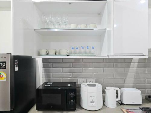 a kitchen with a black microwave and appliances in it at Haus Ekkamai 2 in Khlong Toei