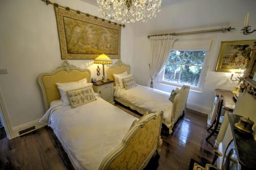 a bedroom with two beds and a chandelier at Beautiful period cottage, exceptional riverside location in the heart of Chester in Chester