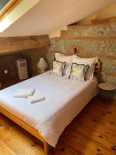 une chambre avec un grand lit blanc avec des oreillers dans l'établissement Toulousaine de 200 m2 10 pers Piscine Jacuzzi proche de Toulouse, à Lagrâce-Dieu