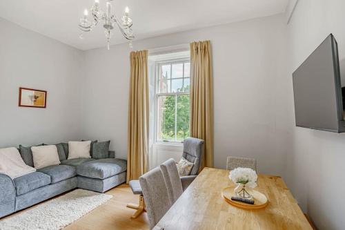 a living room with a table and a couch at Spacious City Apt - Dunfermline in Fife