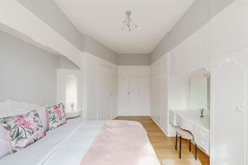 a white bedroom with a large bed and a sink at Spacious City Apt - Dunfermline in Fife