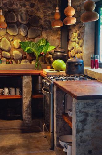 a kitchen with a stove and a stone wall at Unique Tiny House-Best Beach in El Zonte in El Zonte