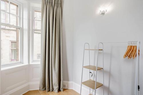 a room with a window with curtains and a shelf at Spacious City Apt - Dunfermline in Fife