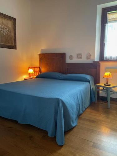 a bedroom with a bed with a blue blanket on it at Agriturismo Clochiatti in Povoletto