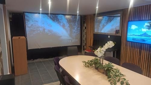 Televízia a/alebo spoločenská miestnosť v ubytovaní Rez de jardin & Salle de réunion