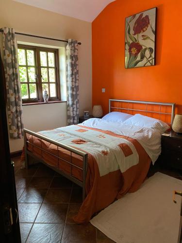 a bedroom with a bed with an orange wall at Marnwood Lodge in Coalbrookdale