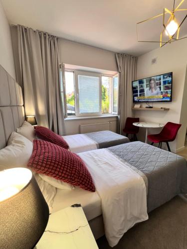 a hotel room with two beds and a flat screen tv at Apartamenty Pokoje Willa Bielany in Warsaw