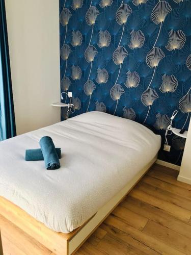 Ce lit se trouve dans une chambre dotée d'un mur bleu. dans l'établissement Le Dupont, 2 chambres & Parking privé, à Grenoble