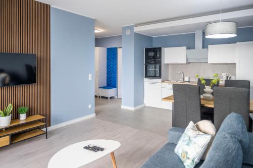 a living room and kitchen with a couch and a table at Apartament Morski by GoApart in Gdańsk