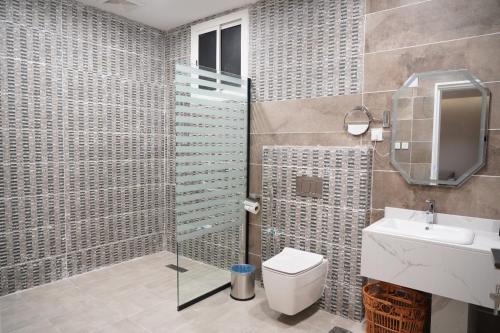 Un baño con ducha, inodoro y lavabo. en فندق ليوبارد الفندقية Leopard Hotel, en Najrán
