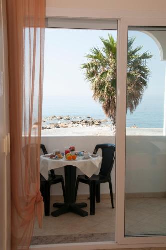 a dining room with a table and a view of the beach at Hotel Kaly in Ventimiglia