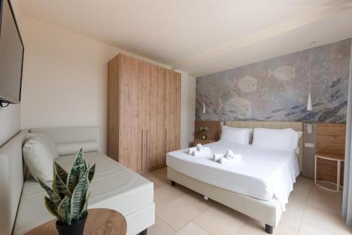 a bedroom with a large white bed and a table at Canado Club Family Village in Marina di Castagneto Carducci