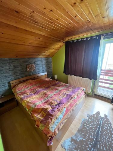a bed in a room with a wooden ceiling at Colt de rai in Bran