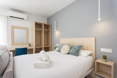 a bedroom with a large white bed with a chair at Estudio Paraiso del Sur in Playa Paraiso