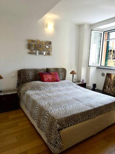 a bedroom with a leopard print bed with a red pillow at Casa ORRI quinto mare e Gaslini in Genova