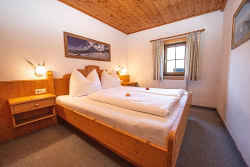 ein Schlafzimmer mit einem Holzbett in einem Zimmer in der Unterkunft Untersulzberghof in Radstadt