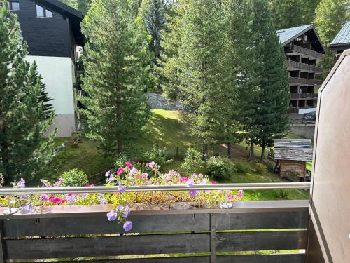 a view from the balcony of a garden with flowers at Hotel Adonis in Zermatt