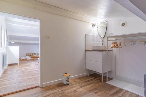Cette chambre est dotée de murs blancs et d'un miroir. dans l'établissement Ecrin Marin - apt terrasse bassin darcachon, à La Teste-de-Buch