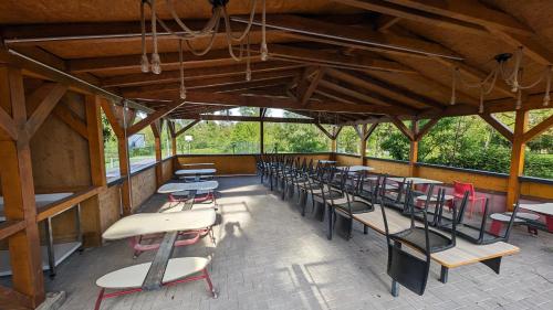 un groupe de tables et de chaises dans un bâtiment dans l'établissement VILLA 50 personnes avec piscine et terrain de tennis et Basket, à Diemeringen