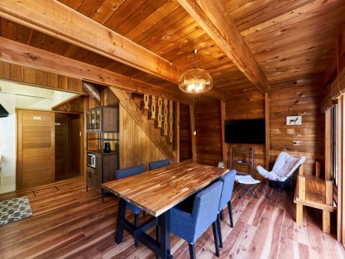 a dining room with a wooden table and blue chairs at LiVEMAX RESORT Hakodate Greenpia Onuma in Mori