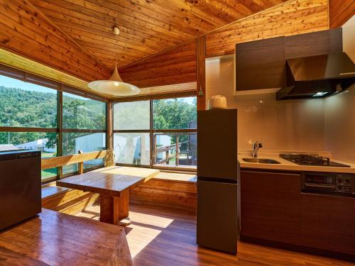 a kitchen with a table and a large window at LiVEMAX RESORT Hakodate Greenpia Onuma in Mori