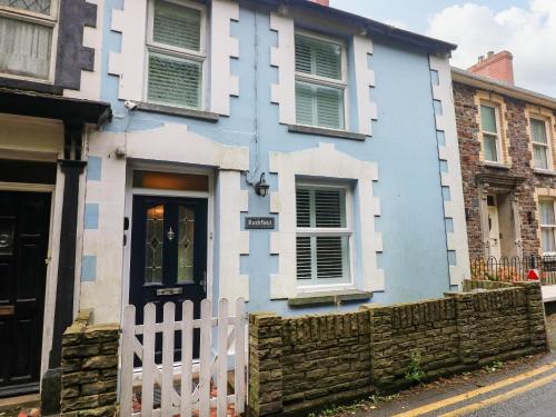 a blue and white house with a white fence at Rushfield in Cardigan
