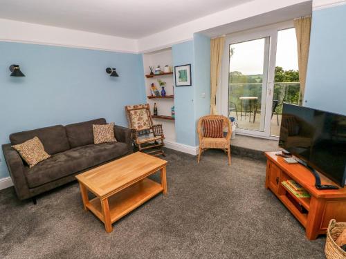 a living room with a couch and a tv at Rushfield in Cardigan