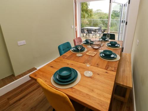 a dining room table with chairs and a large window at Rushfield in Cardigan