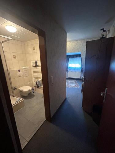 a room with a bathroom with a toilet and a door at Gasthaus Zur Krone in Langenfeld