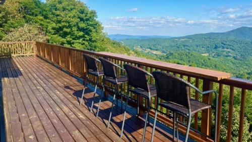 three chairs on a deck with a view of mountains at Grandview Haven in Banner Elk