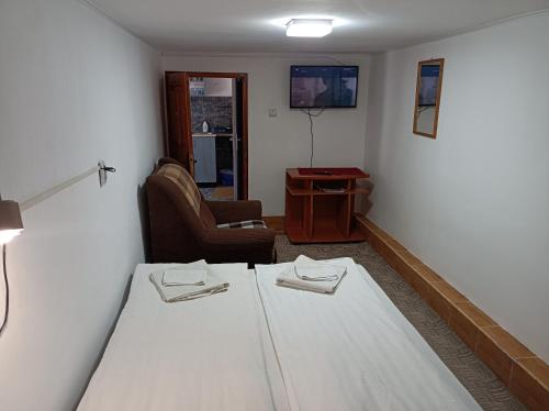 a room with a white table and a chair at Gyongyver Panzio in Sfântu-Gheorghe