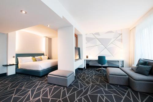 a hotel room with a bed and a couch at Warwick Le Crystal - Montréal in Montréal
