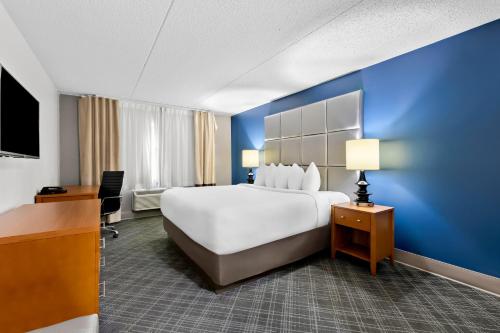 a hotel room with a large bed and a blue wall at Comfort Inn & Suites Nashville Near Tanger Outlets I-24 Antioch in Antioch