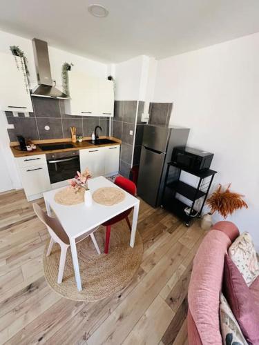 un salon avec une table et une cuisine dans l'établissement Studio Renard, style bohème et atypique, Curistes, à Luxeuil-les-Bains