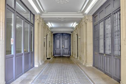 un couloir vide avec une porte bleue dans un bâtiment dans l'établissement Urban Flat 09 - Stylish Triplex Champs-Elysees, à Paris