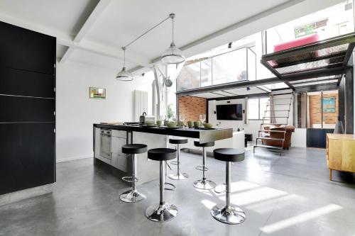 une cuisine avec un bar et des tabourets. dans l'établissement Somptuous Apartement Terrace-2BR-6PCenter of Paris, à Paris