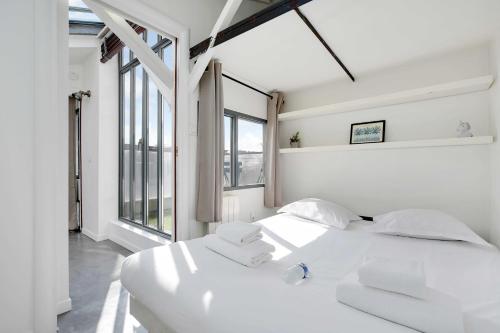 - une chambre blanche avec 2 lits et de grandes fenêtres dans l'établissement Somptuous Apartement Terrace-2BR-6PCenter of Paris, à Paris