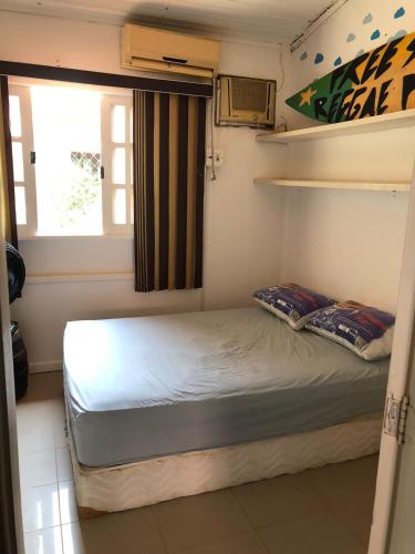 a small bedroom with a bed and a window at Paraíso na cidade in Salvador