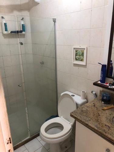 a bathroom with a toilet and a glass shower at Paraíso na cidade in Salvador